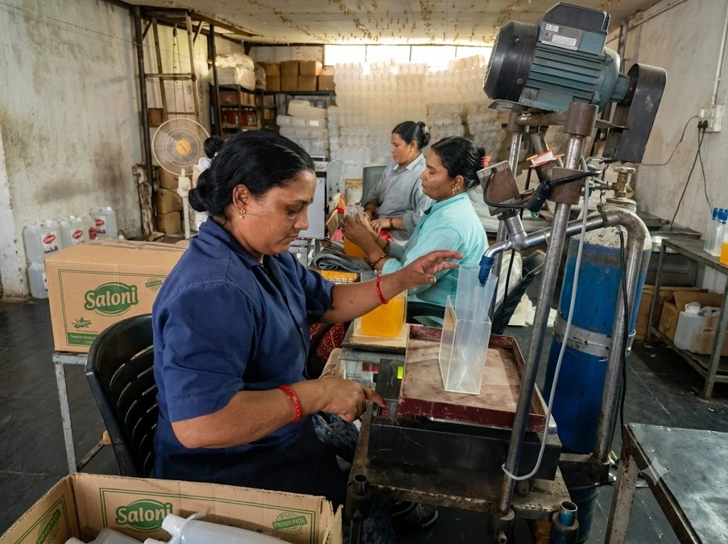 Women filling liquid cleaning product pouches in the Saloni production area